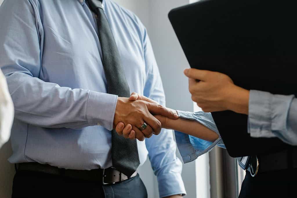 an image of two people shaking hands for acquisitions agreement